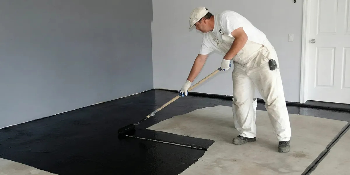 basement waterproofing professional applying waterproof coating to protect a basement floor in Salt Lake City, UT